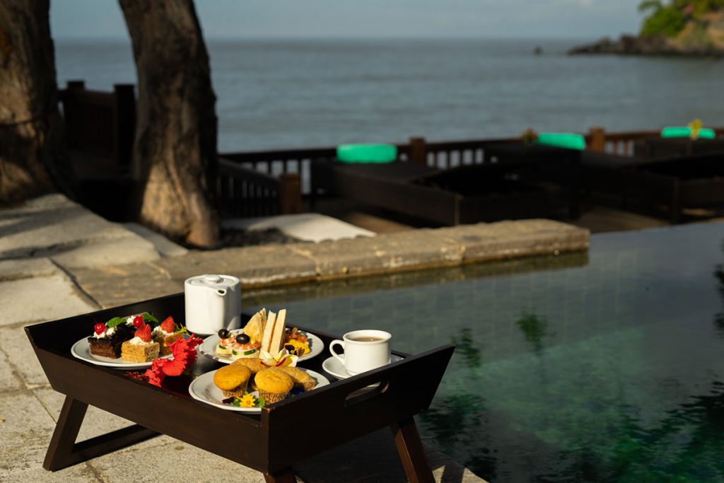 Afternoon tea with cakes, sandwiches, tea and coffee by the beachfront swimming pool in Mimpi Resort Tulamben, East Bali